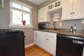 kitchen with light wood-type flooring, white cabinetry, sink, and black appliances