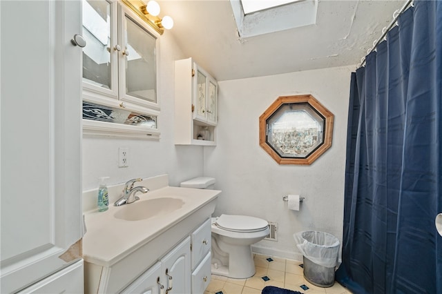 bathroom with walk in shower, vanity, tile patterned flooring, toilet, and a skylight