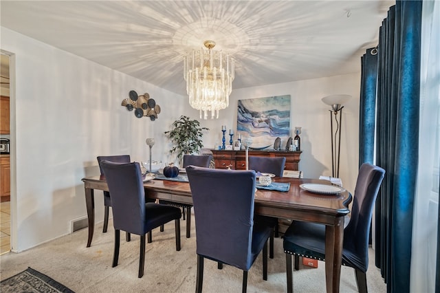 dining area featuring an inviting chandelier and light carpet