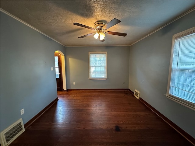 spare room with ceiling fan, dark wood-type flooring, crown molding, and a textured ceiling