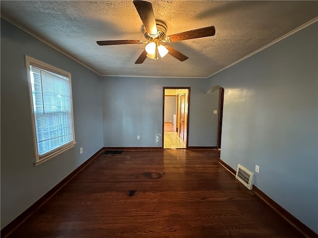 unfurnished room featuring a textured ceiling, dark hardwood / wood-style floors, ceiling fan, and crown molding