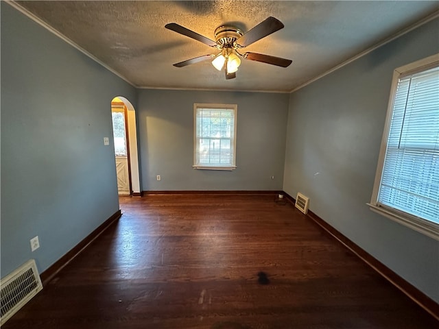 empty room featuring a textured ceiling, dark hardwood / wood-style floors, ceiling fan, and ornamental molding