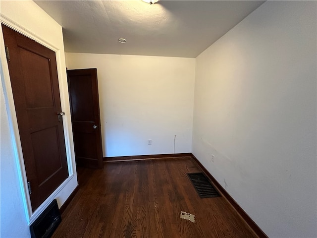 unfurnished room with dark wood-type flooring