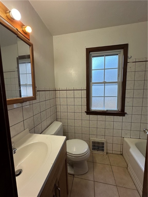 bathroom featuring tile patterned flooring, vanity, and tile walls