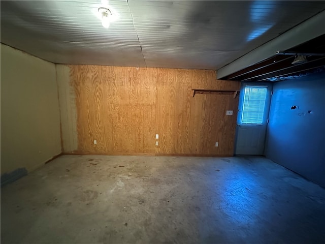 basement featuring wooden walls