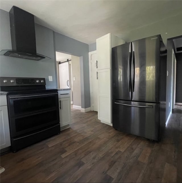 kitchen with white cabinetry, black electric range, a barn door, stainless steel fridge, and wall chimney range hood