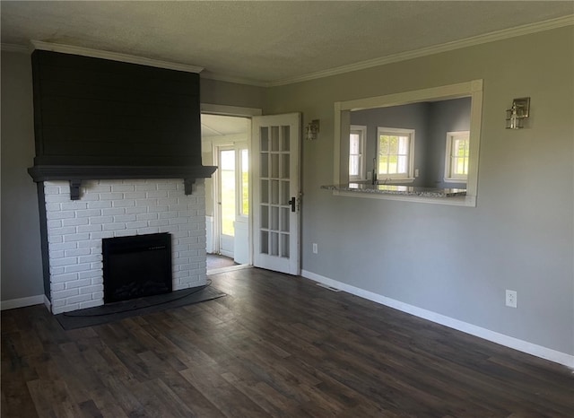 unfurnished living room featuring dark wood-type flooring, a wealth of natural light, a textured ceiling, and ornamental molding