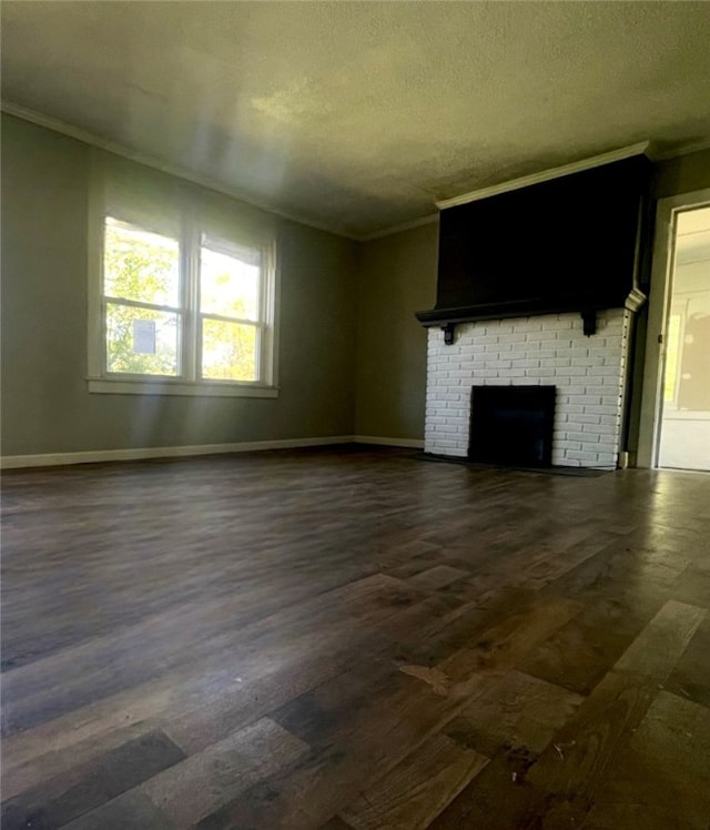 unfurnished living room with a textured ceiling, crown molding, dark hardwood / wood-style floors, and a brick fireplace