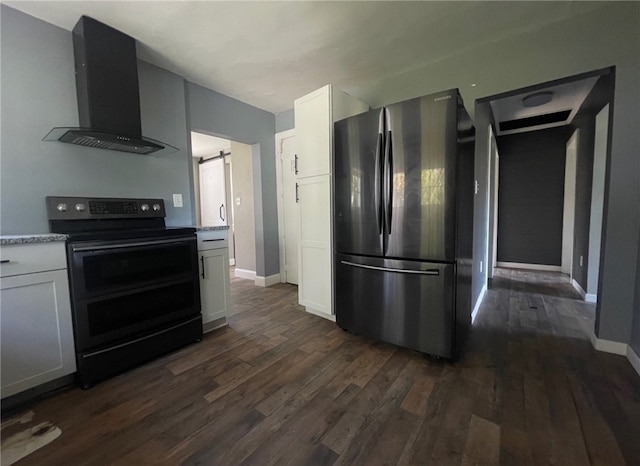 kitchen featuring stainless steel refrigerator, white cabinetry, wall chimney exhaust hood, a barn door, and electric range