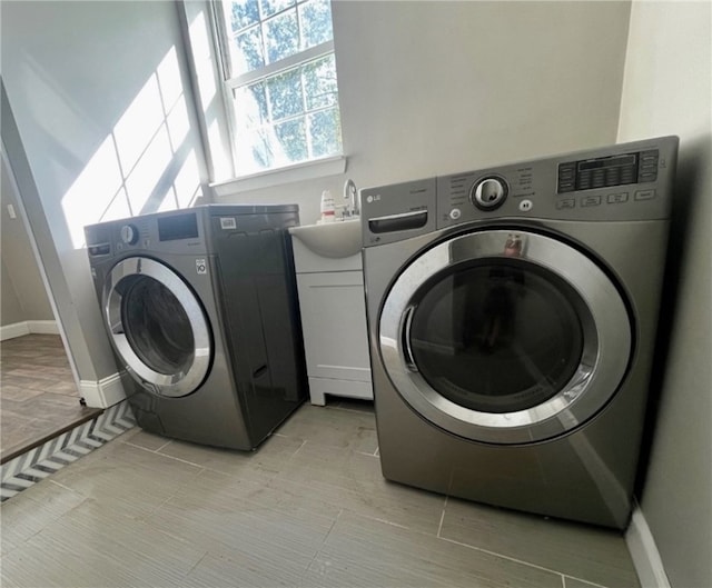 clothes washing area featuring washer and clothes dryer and sink