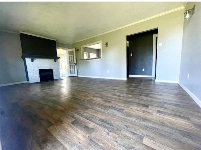 unfurnished living room with a brick fireplace, dark hardwood / wood-style floors, and ornamental molding