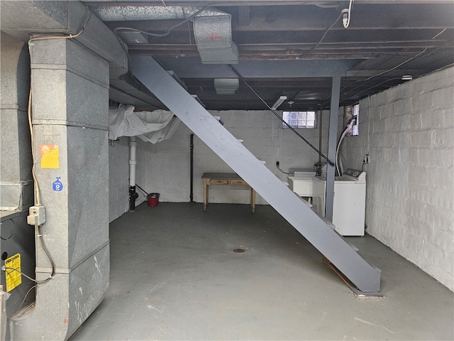 basement featuring heating unit and washer / dryer