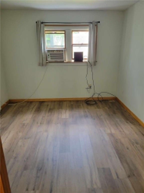 spare room with wood-type flooring and cooling unit