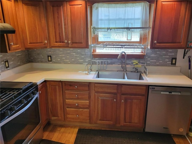 kitchen with dark wood-type flooring, tasteful backsplash, appliances with stainless steel finishes, and sink