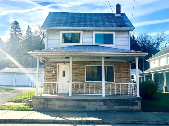 view of front of property with a garage, a porch, and an outbuilding