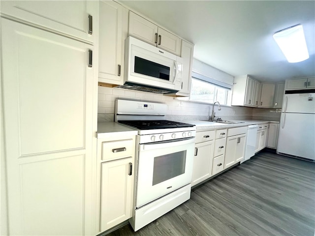 kitchen with white cabinetry, backsplash, sink, dark wood-type flooring, and white appliances