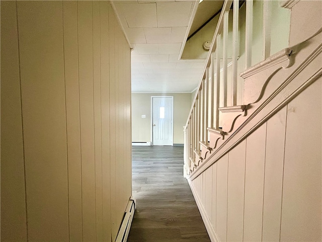 staircase with hardwood / wood-style floors and a baseboard heating unit