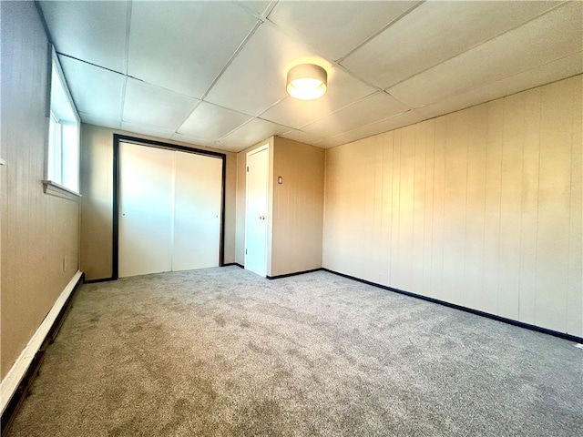 unfurnished bedroom featuring carpet and baseboard heating