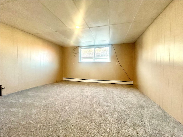 spare room with a baseboard heating unit and carpet