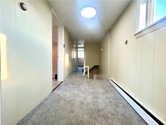 hallway featuring light colored carpet and a baseboard heating unit