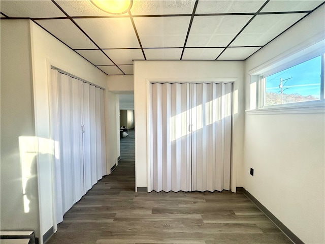 interior space featuring dark wood-type flooring, a closet, and a drop ceiling