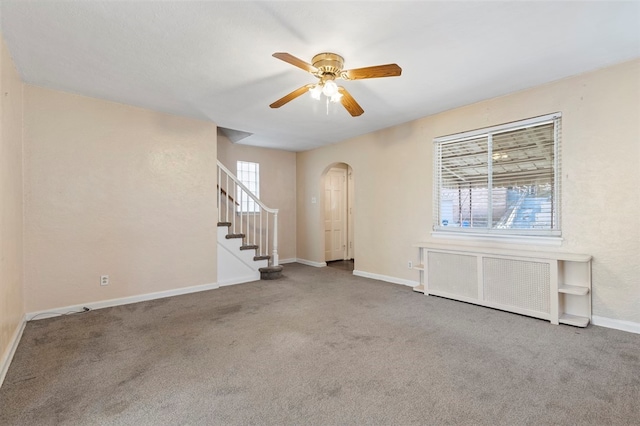 unfurnished room with radiator heating unit, carpet floors, and ceiling fan