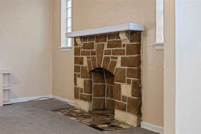 interior details featuring a fireplace and carpet