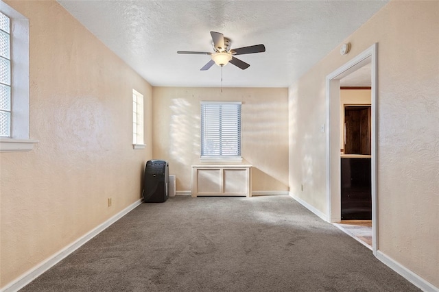 carpeted empty room featuring a textured ceiling and ceiling fan