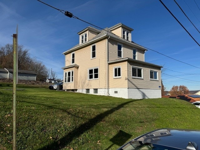 view of side of home with a lawn