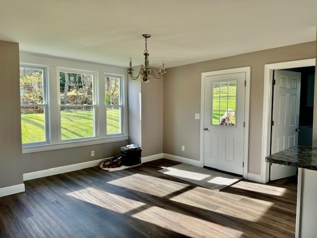 unfurnished dining area featuring dark hardwood / wood-style floors and an inviting chandelier