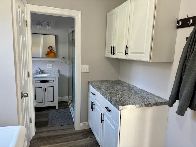 kitchen with dark hardwood / wood-style floors, white cabinetry, and sink