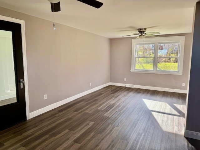 empty room with dark hardwood / wood-style flooring and ceiling fan