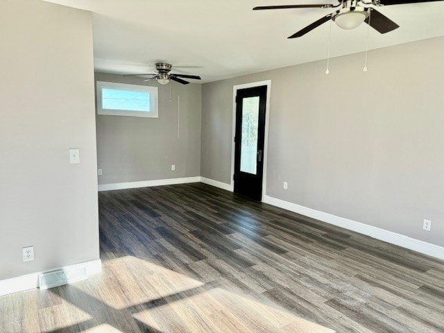 empty room with dark wood-type flooring and ceiling fan