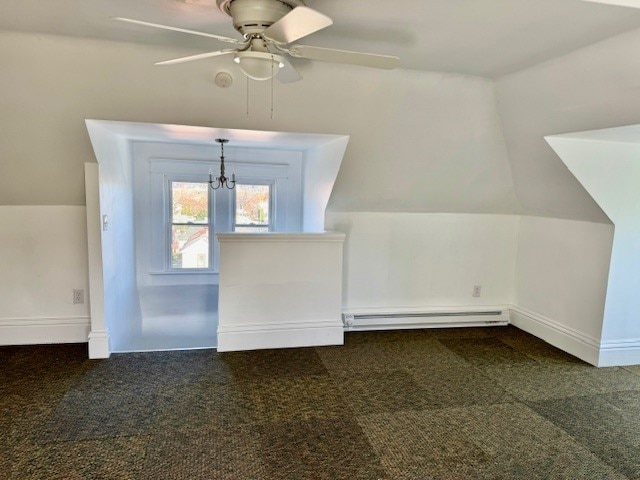 additional living space with ceiling fan with notable chandelier, a baseboard radiator, lofted ceiling, and dark carpet