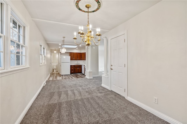 unfurnished living room with a chandelier, sink, and carpet