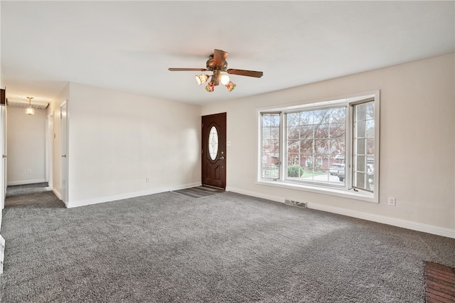 interior space featuring dark colored carpet and ceiling fan