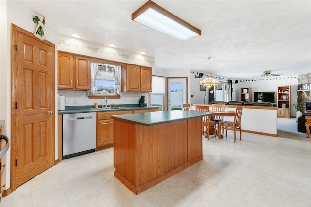 kitchen with hanging light fixtures, sink, dishwasher, ceiling fan, and a center island