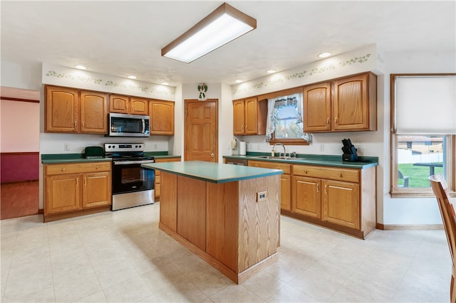 kitchen with appliances with stainless steel finishes, sink, and a center island