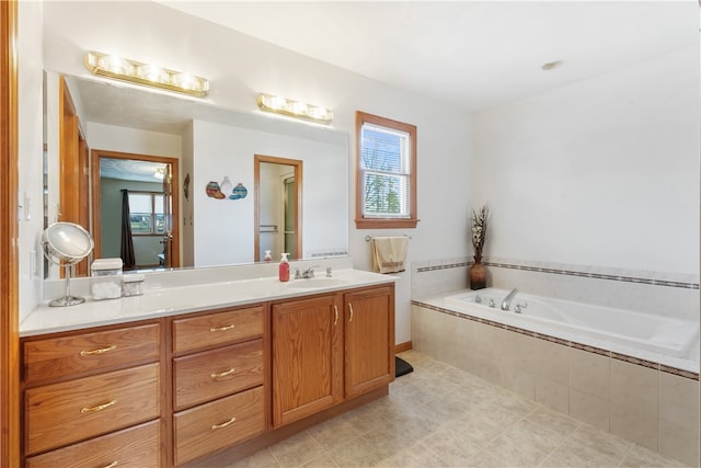 bathroom featuring vanity, tiled bath, and tile patterned flooring