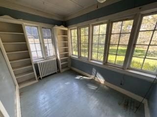 unfurnished sunroom featuring radiator heating unit