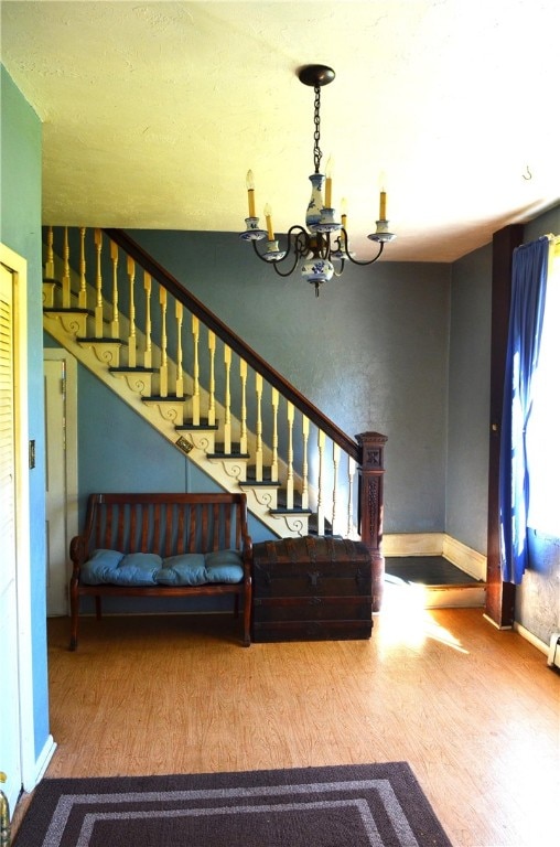 stairs with hardwood / wood-style flooring and an inviting chandelier