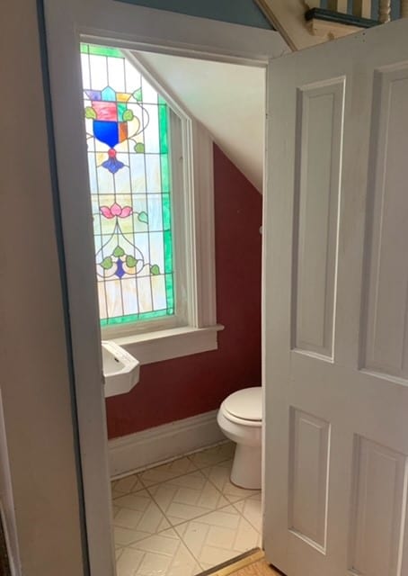 bathroom featuring lofted ceiling and toilet