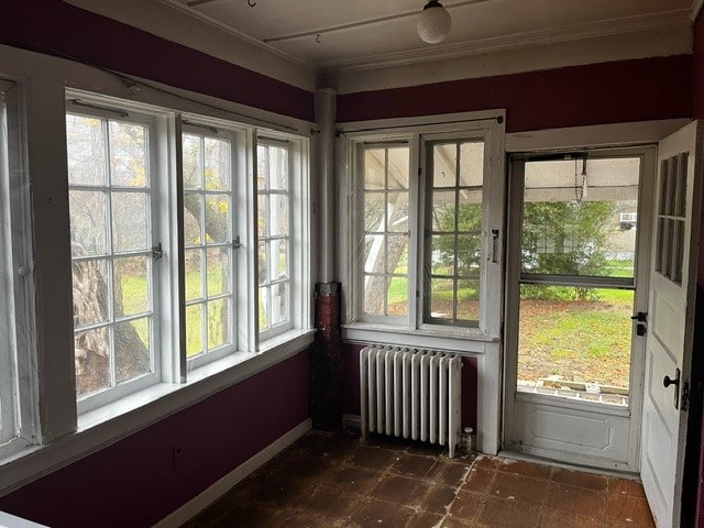 unfurnished sunroom with radiator and a wealth of natural light