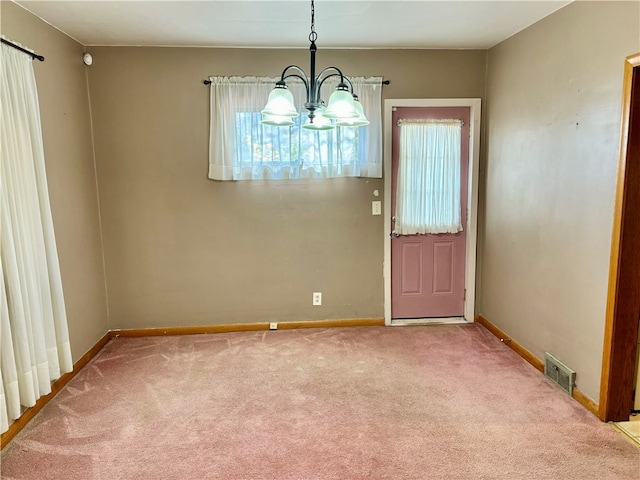 unfurnished dining area featuring plenty of natural light, a notable chandelier, and light colored carpet