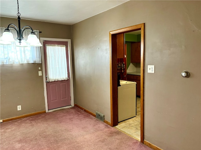 doorway to outside featuring washer / dryer, light colored carpet, and a chandelier