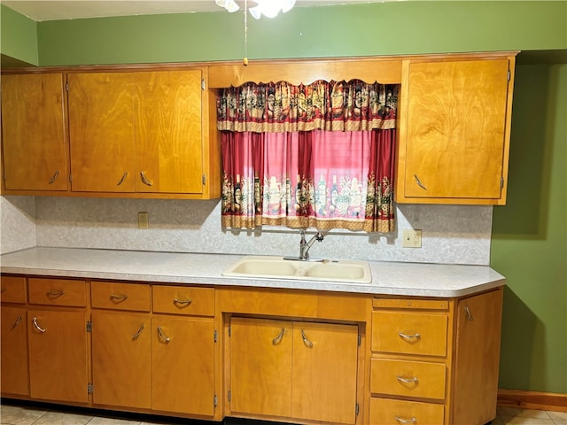 kitchen with light tile patterned flooring, sink, and tasteful backsplash