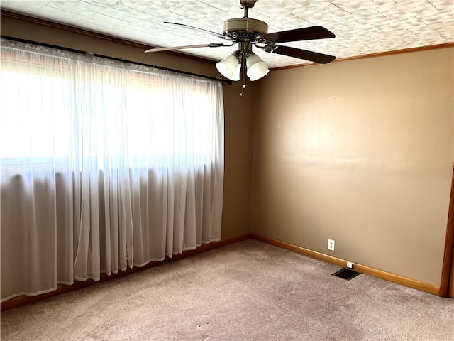 carpeted empty room with ceiling fan and ornamental molding