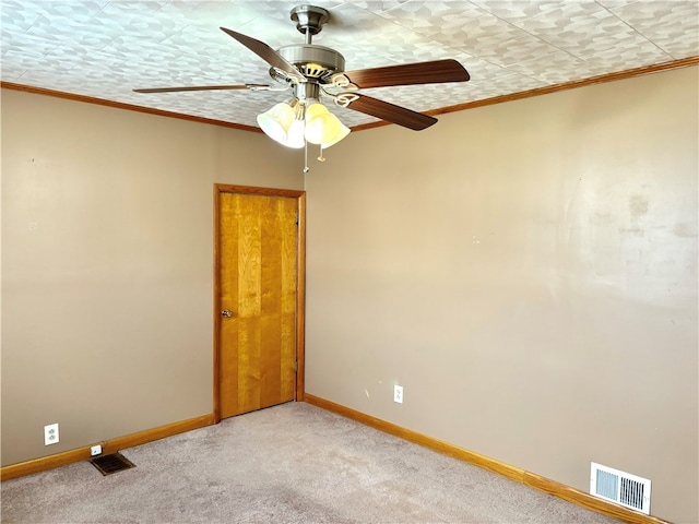 spare room featuring a textured ceiling, light carpet, ceiling fan, and crown molding