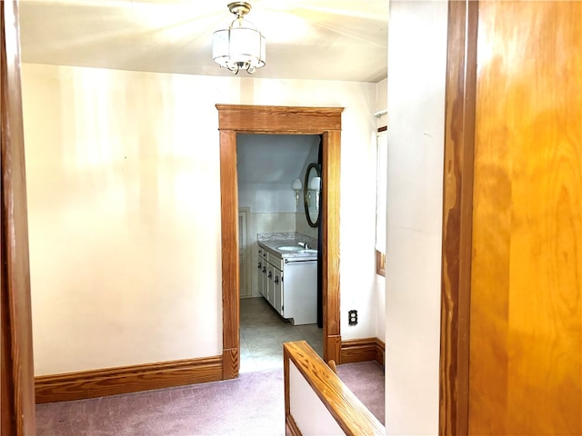 corridor featuring light colored carpet and sink