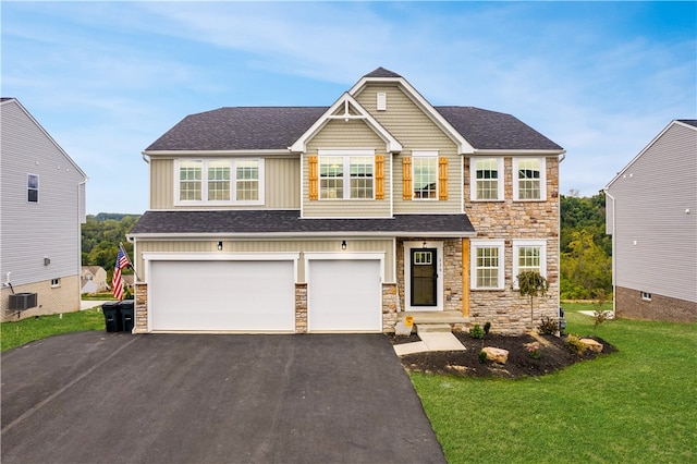 craftsman inspired home featuring cooling unit, a front lawn, and a garage